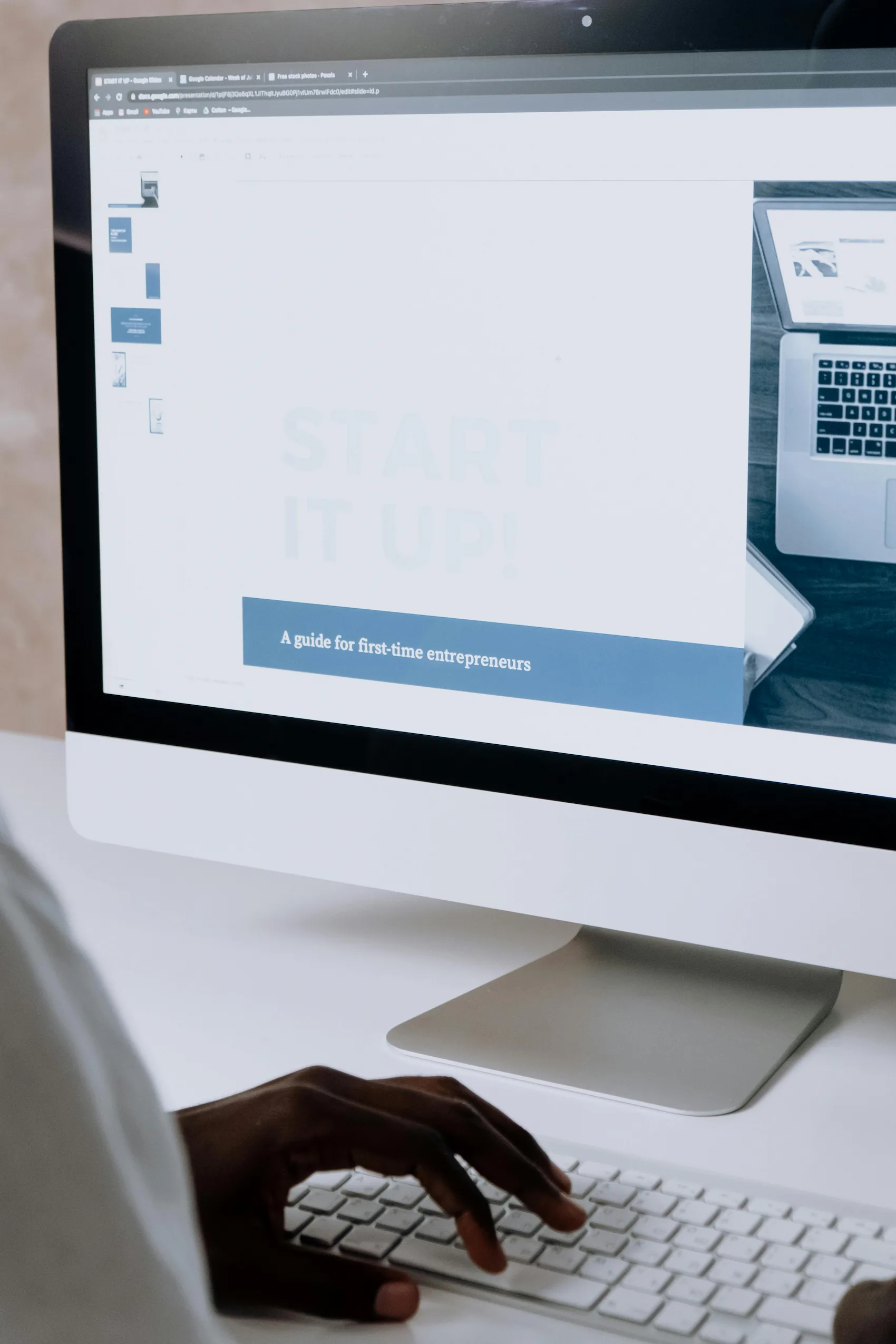 A person working at a desktop computer on a business planning document